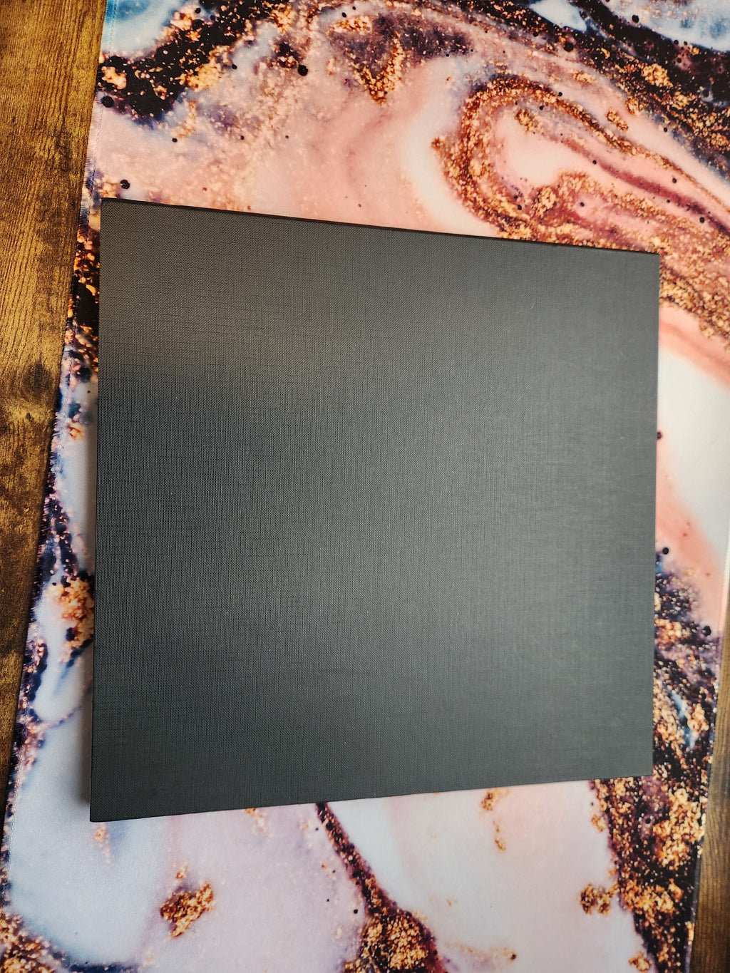 Back side of the foldable Wildfire Mayhem game board showing plain black surface on a marbled background
