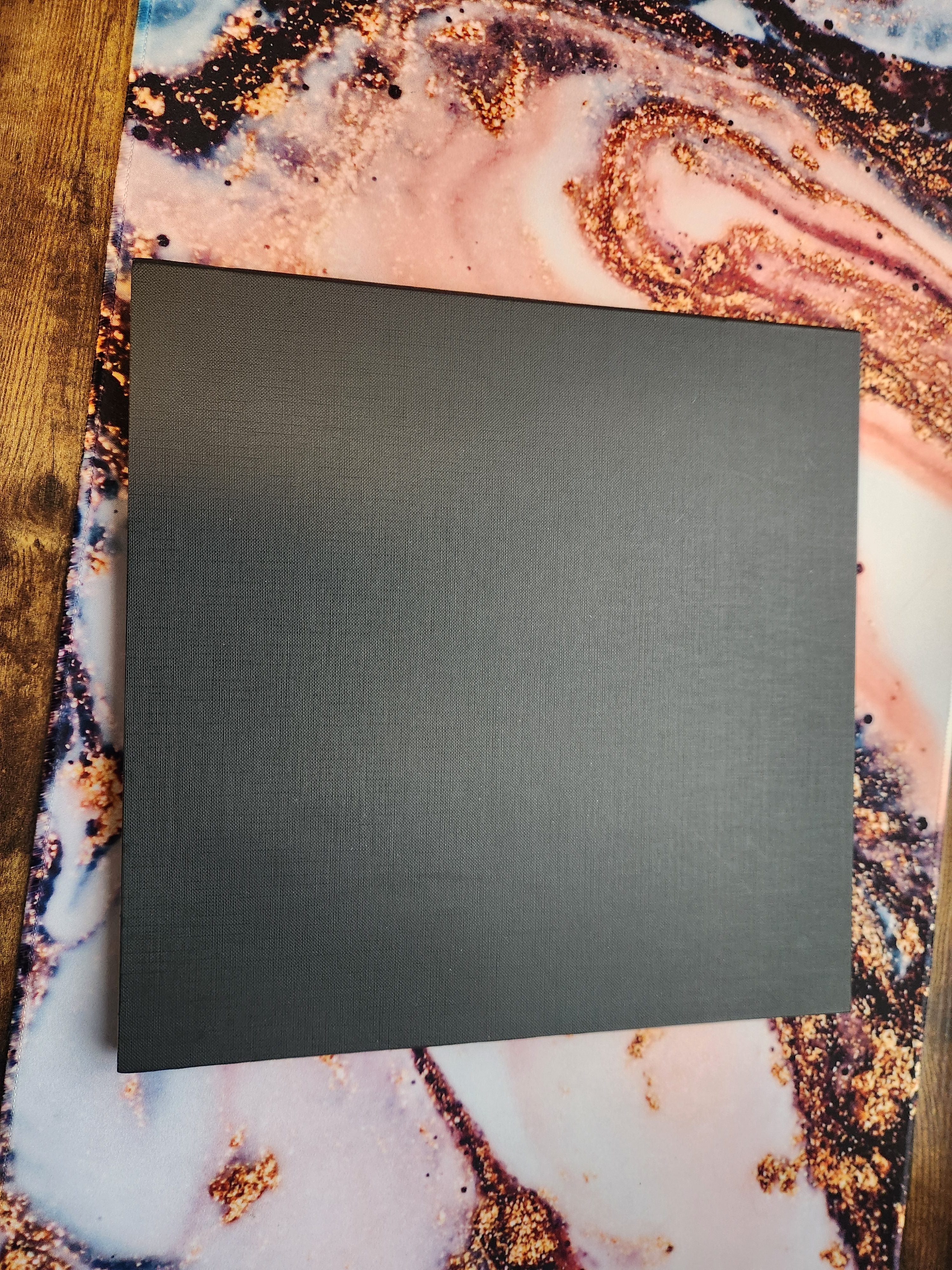 Back side of the foldable Wildfire Mayhem game board showing plain black surface on a marbled background
