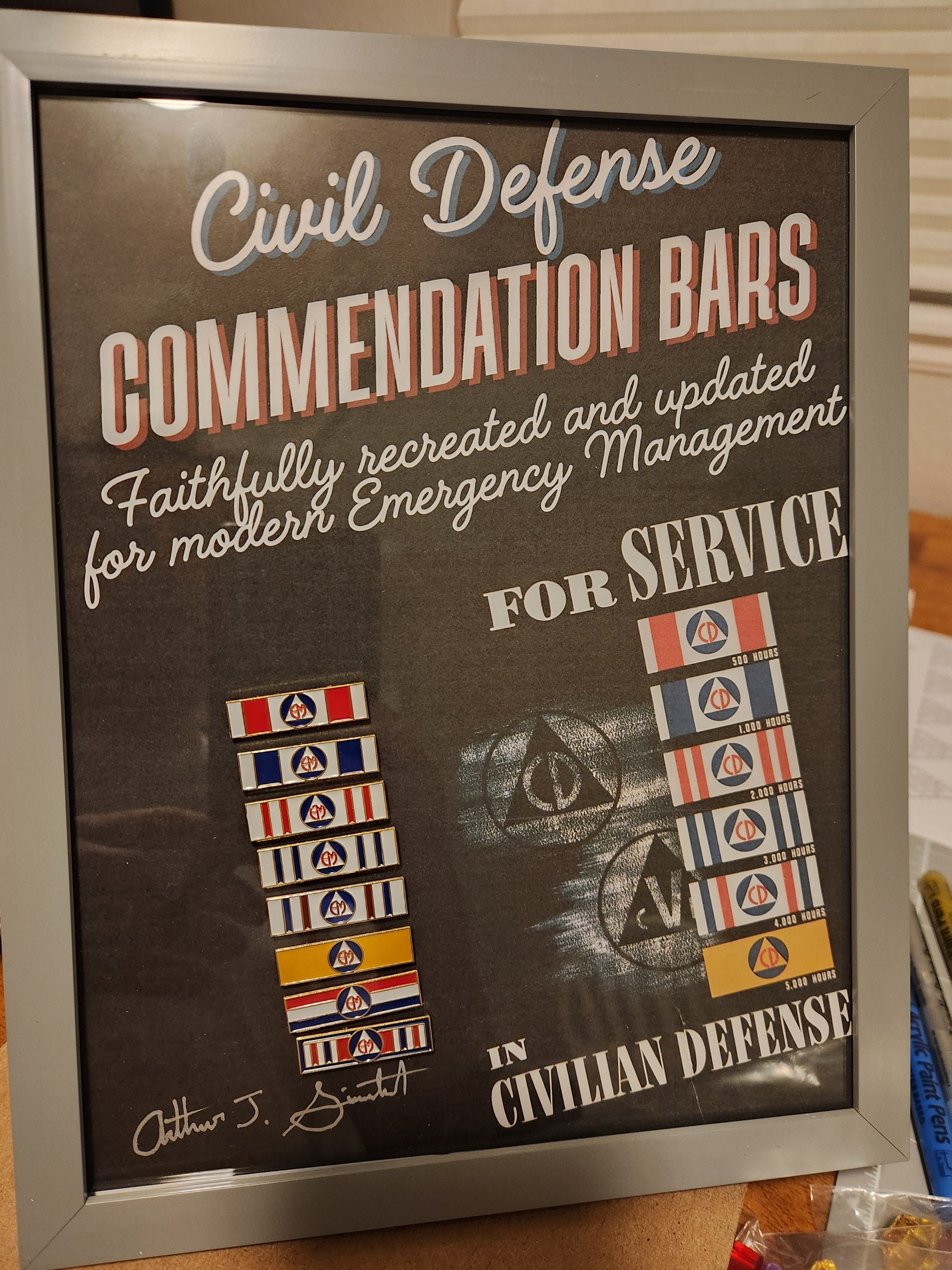 Framed poster displaying Civil Defense Commendation Bars for modern emergency management, with multiple ribbons.